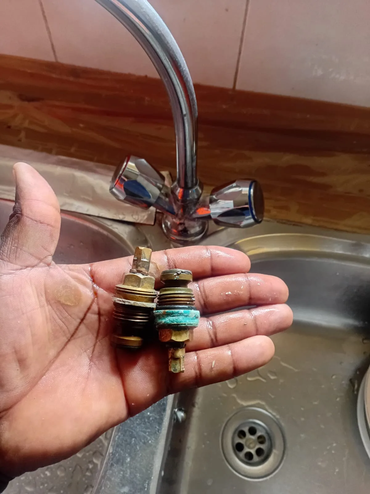 Close-up of removed tap cartridges during a Cresta kitchen mixer repair.