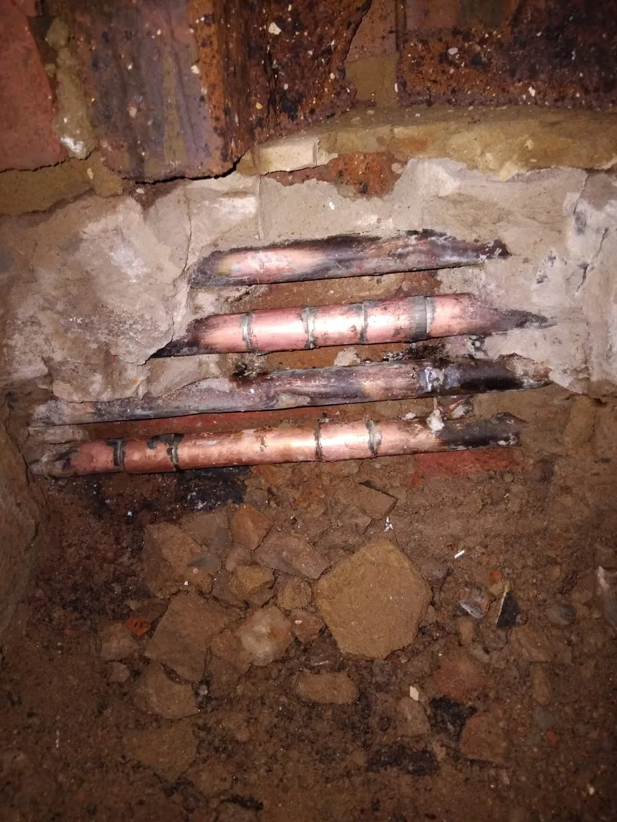 Copper water lines rerouted through an opened wall cavity during pipe rerouting work.
