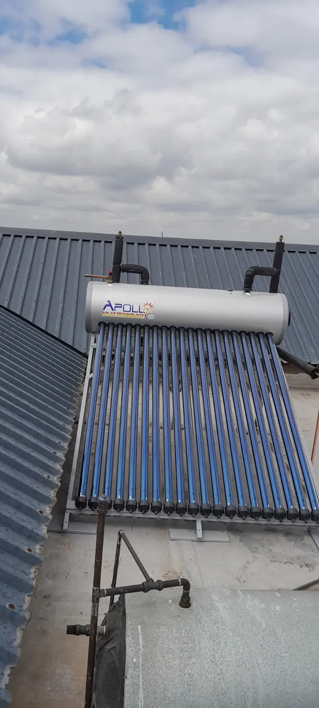 Solar geyser installation with evacuated tubes and storage cylinder mounted on a roof.